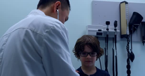 Vista Trasera Del Joven Médico Masculino Asiático Examinando Tórax Niño — Vídeo de stock