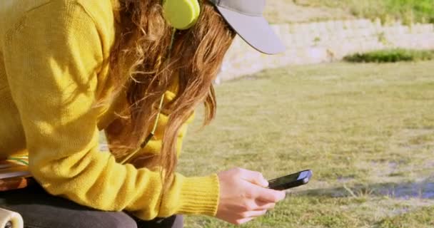 Vista Lateral Una Joven Mujer Caucásica Escuchando Música Usando Teléfono — Vídeo de stock