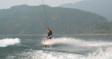 Önden Görünümü üzerinde şehir nehre wakeboard yapan beyaz delikanlı. Wakeboard ip 4 k tutan binici