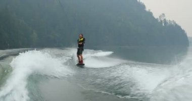 Önden Görünümü üzerinde şehir nehre wakeboard yapan beyaz delikanlı. Wakeboard ip 4 k tutan binici
