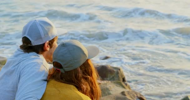 Bakifrån Unga Kaukasiska Par Sitta Sten Och Titta Havet Stranden — Stockvideo