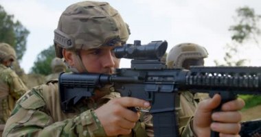 Arkadan görünüş alanında askeri eğitim sırasında eğitim karışık ırk askeri askerleri tüfek. Ayakta ve tüfeği 4 k hedefleyen