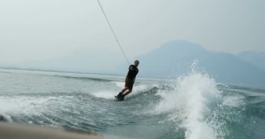 Önden Görünümü üzerinde şehir nehre wakeboard yapan beyaz delikanlı. Wakeboard ip 4 k tutan binici