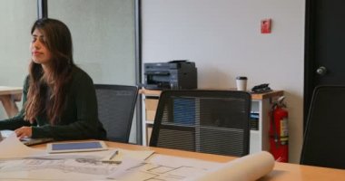 Genç Asyalı işkadını modern ofisindeki kahve fincanı ile yürüme önden görünümü. Asya işkadını üstünde laptop 4 k çalışıyordu