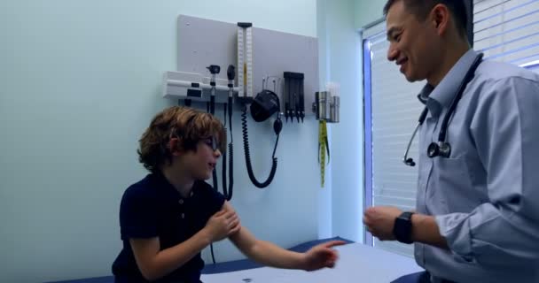 Genç Asyalı Erkek Yan Görünüm Doktor Kliniğinde Beyaz Çocuk Hasta — Stok video