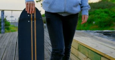 Genç beyaz kadın kaykaycı kaykay gözlem noktası ile yürüme önden görünümü. Bayan kaykaycı dış saha 4 k arıyorsunuz