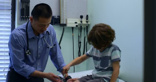 Vista Frontal Joven Médico Masculino Asiático Examinando Niño Caucásico Paciente — Vídeos de Stock