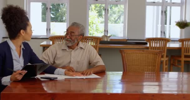 Gemengd Ras Vrouwelijke Makelaar Bespreken Eigendommen Met Senior Man Thuis — Stockvideo