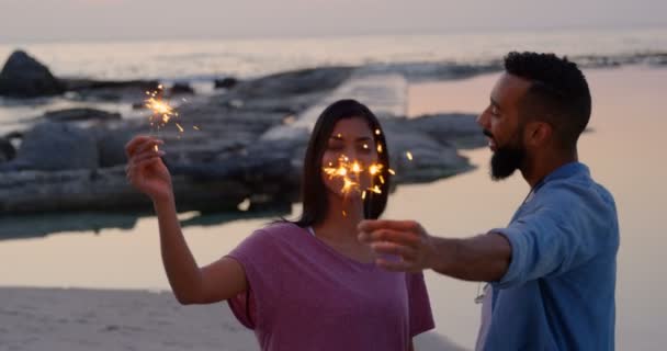 Glückliches Junges Gemischtes Paar Das Sich Strand Mit Wunderkerzen Vergnügt — Stockvideo