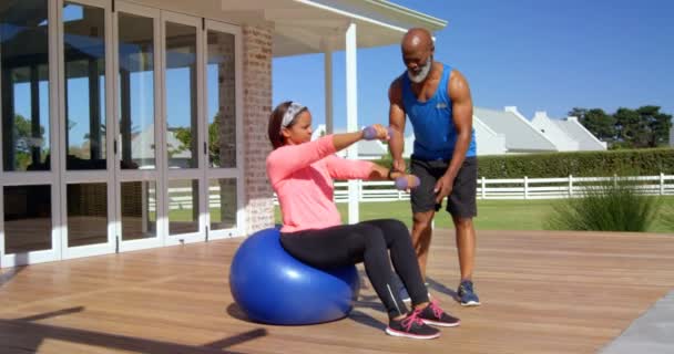 Взрослый Мужчина Смешанной Расы Помогает Зрелой Женщине Упражнениях Заднем Дворе — стоковое видео