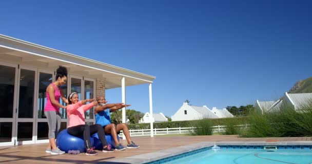 在后院与成熟的黑人夫妇进行混合种族女教练员锻炼的侧视图 他们正在用运动球 在阳光下锻炼 — 图库视频影像
