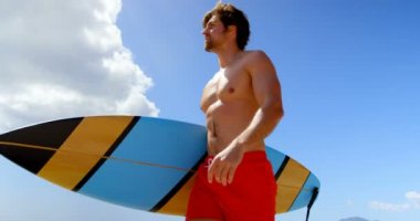 Alt görünümü 4 k kumsalda onun surfboard holding sörfçü adam