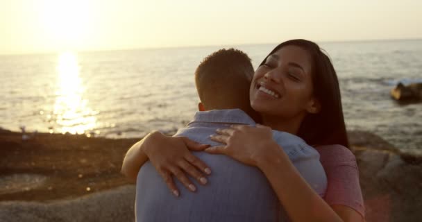 浪漫的年轻混血情侣拥抱对方在海滩上 日落时站在海滩上的浪漫的混血儿4K — 图库视频影像