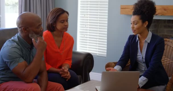 混血女房地产经纪人讨论财产与成熟夫妇在笔记本电脑上的家 他们正在互相握手 — 图库视频影像