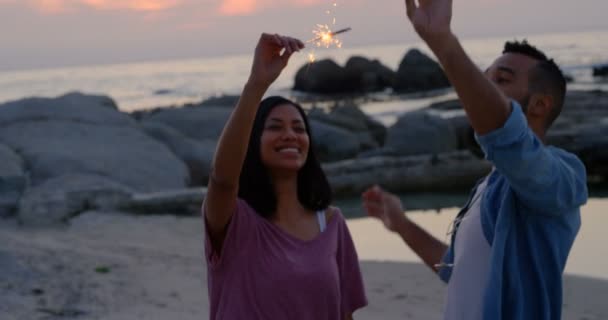 Glückliches Junges Gemischtes Paar Das Sich Strand Mit Wunderkerzen Vergnügt — Stockvideo