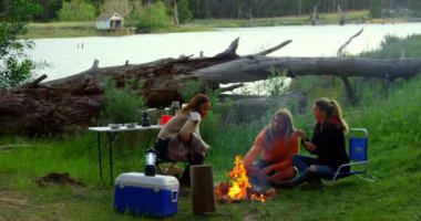 Arkadaşlar birbirleri ile kamp ateşi etkileşim. Birlikte 4 k ormanda kamp arkadaşları