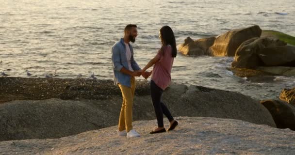 Mixed Race Couple Holding Hands While Standing Rock Beach Romantic — Stock Video