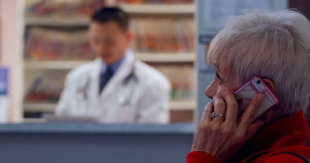 Zijaanzicht Van Kaukasische Senior Patiënt Praten Mobiele Telefoon Bij Kliniek — Stockvideo