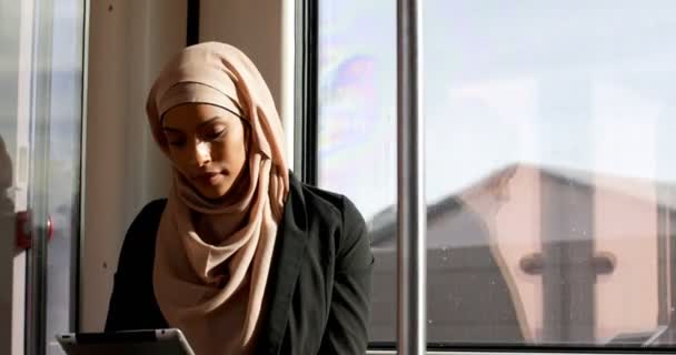 亚洲年轻女子在头巾使用数字平板电脑和火车旅行的正面看法 坐在4K 火车上的年轻亚洲妇女 — 图库视频影像