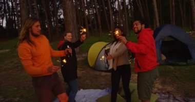 Arkadaşlar ormanda havai fişekleri ile eğleniyor. Birlikte 4 k ormanda kamp arkadaşları