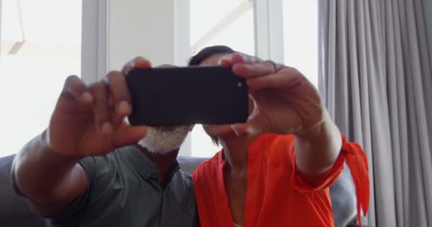 在一个舒适的家中 成熟的黑人夫妇点击自拍手机自拍的正面视图 他们面带微笑 摆出4K 的姿势 — 图库视频影像