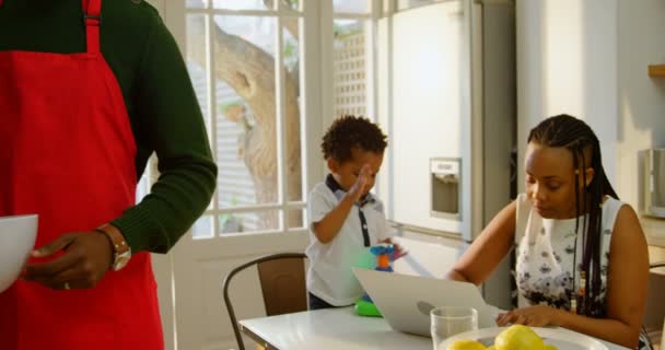 Framsida Svart Ung Mamma Arbetar Laptop Och Son Spelar Matbordet — Stockvideo