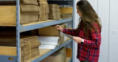 Ambar stok kontrol beyaz kadın işçi yan görünüm. Beyaz kadın işçisi dijital tablet 4 k