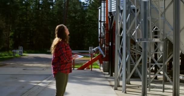 Vista Laterale Della Lavoratrice Caucasica Che Guarda Serbatoi Stoccaggio Che — Video Stock