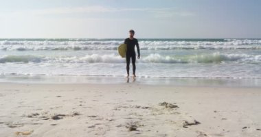 Erkek sörfçü Plajı'nda sörf tahtası ile yürüme. Erkek surfer sörf tahtası 4 k tutan