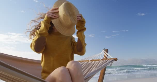 Γυναίκα Φοράει Καπέλο Στην Παραλία Γυναίκα Χαλαρώνοντας Στην Αιώρα — Αρχείο Βίντεο