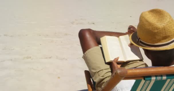 Man Läser Bok Stranden Man Kopplar Sunlounger — Stockvideo