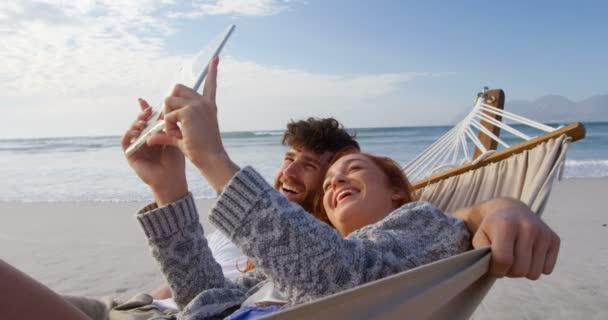 Couple Utilisant Une Tablette Numérique Plage Couple Relaxant Sur Hamac — Video