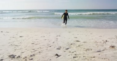 Kumsalda Surfboard ile çalışan erkek sörfçü. Erkek surfer sörf tahtası 4 k tutan