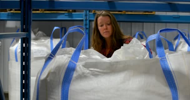 倉庫で在庫をチェック白人女性労働者のフロント ビュー ラック パレットの商品を満載 — ストック動画