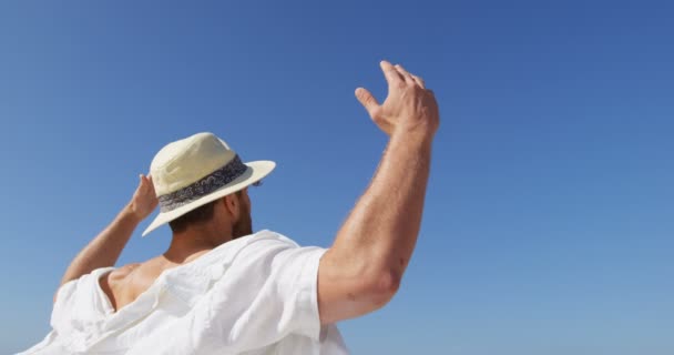 Güneşli Bir Plaj Şapka Duran Adam Planda Mavi Gökyüzü — Stok video