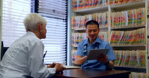 Joven Médico Asiático Paciente Senior Discutiendo Través Tableta Digital Clínica — Vídeo de stock