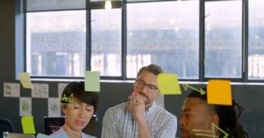 Şirket yöneticileri yapışkan not office üzerinde tartışıyor. Şirket yöneticileri birlikte çalışan 4 k