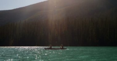 Genç bir çift kürek tekne yan görünüm güneş turkuaz Nehri üzerinde. Onlar are istimal kürek 4 k