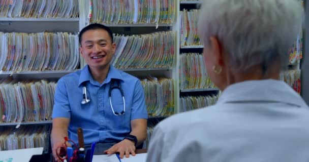 Young Asian Male Doctor Senior Patient Interacting Each Other Clinic — Stock Video