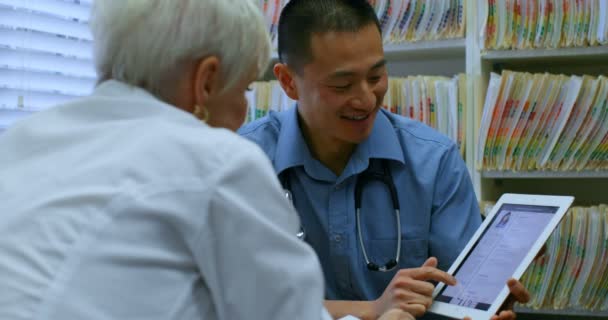 Joven Médico Asiático Paciente Senior Discutiendo Través Tableta Digital Clínica — Vídeo de stock