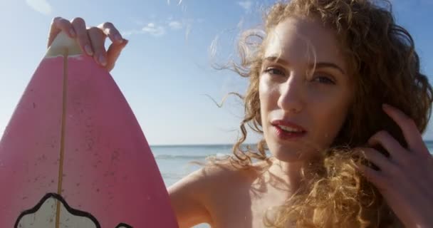 女性冲浪者站在海滩上冲浪板 看着相机4K 的女性冲浪者 — 图库视频影像