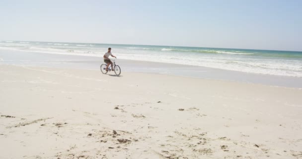 Man Rider Cykel Stranden Solig Dag Havet Vågor Bakgrunden — Stockvideo