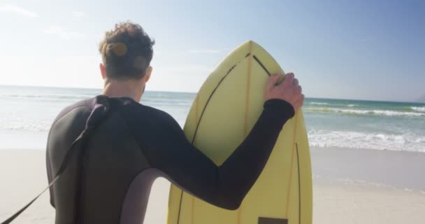Αρσενικό Surfer Στέκεται Σανίδα Του Σερφ Στην Παραλία Οπίσθια Όψη — Αρχείο Βίντεο