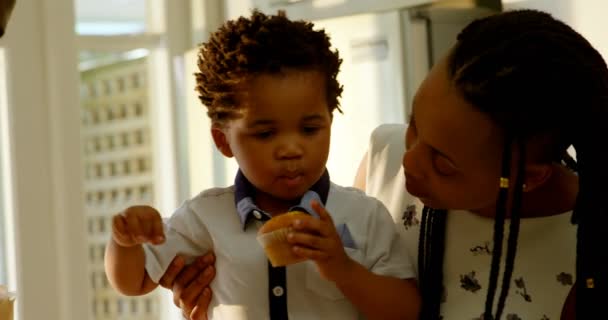 Vista Frontal Lindo Hijo Negro Comiendo Magdalena Cocina Hogar Cómodo — Vídeo de stock