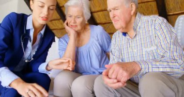 Beyaz kadın doktor ilaç rahat ev kıdemli çifte ile tartışmaya açık bakış. Beyaz kadın doktor hap üst düzey çift 4 k için gösterilen