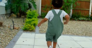 Dikiz evlerinin arka bahçesinde oynarken şirin siyah bebek. O çalıştıran ve çakıl 4 k alarak