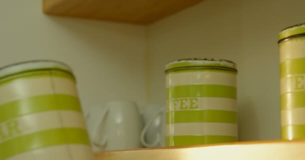 关闭妇女把一个绿色的糖罐在架子4K — 图库视频影像