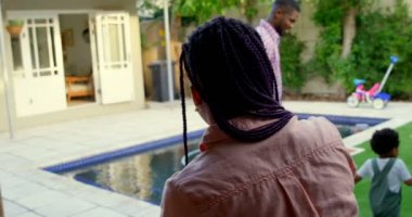 Genç siyah baba ve küçük oğlu evlerinin arka bahçesinde oynarken arka görüş. Annem onları 4 k arıyorsunuz