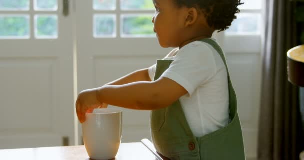 Vista Lateral Niño Negro Lindo Jugando Con Taza Café Sala — Vídeos de Stock