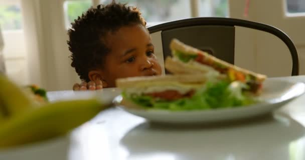 Vooraanzicht Van Schattige Kleine Zwarte Jongen Zittend Leerstoel Aan Eettafel — Stockvideo